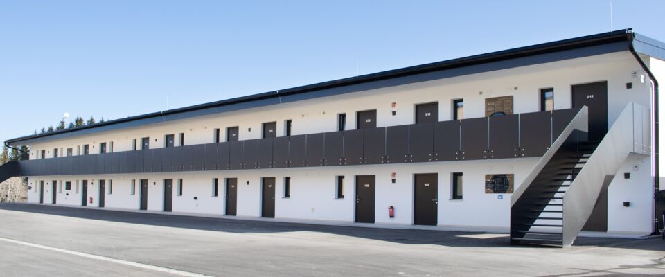 Zweistöckige modulare Unterkunft mit Außengang und Treppenaufgang.