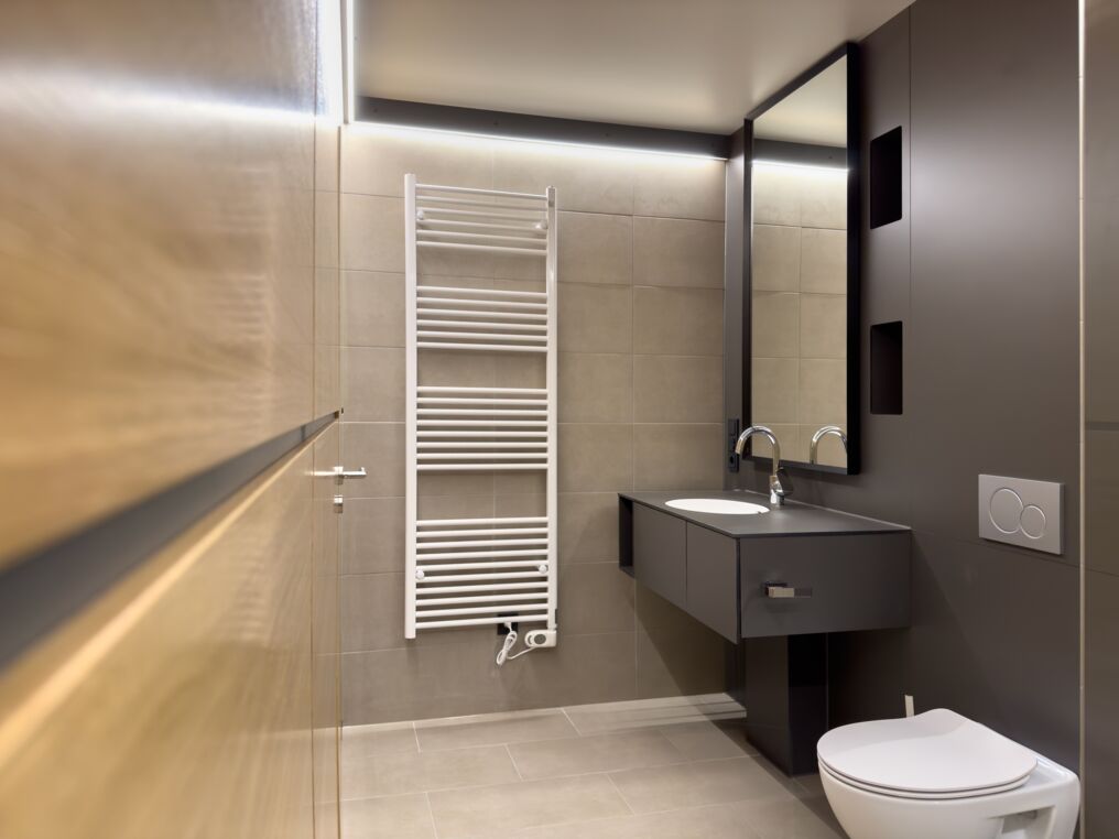 Modernes Badezimmer mit Heizkörper Modernes Badezimmer mit Waschbecken, Spiegel, Toilette und Heizkörper.